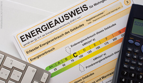 Ein ausgedruckter Energieausweis, daneben lieget eine Tastatur und ein Taschenrechner