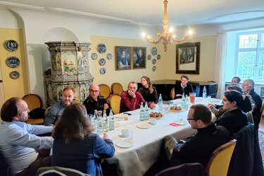 Teilnehmer sitzen an einem Tisch und tauschen sich aus