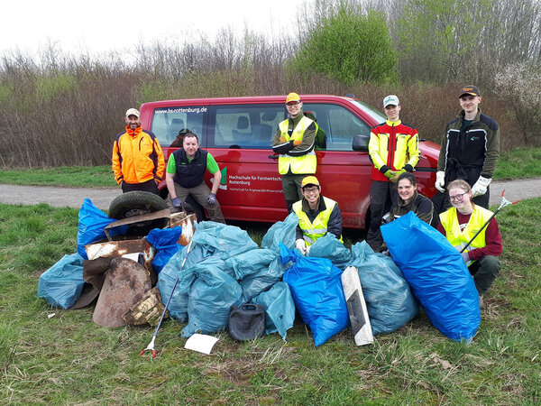 Gruppenfoto mit den Teilnehmern. Davor der gesammelte Müll in Müllsäcken