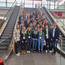 Gruppenfoto mit den Teilnehmern an einer Rolltreppe im Messegebäude