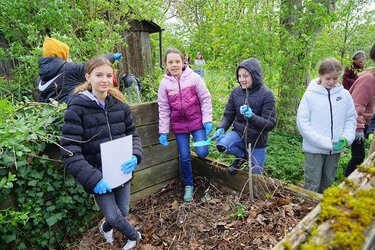 SchülerInnen an einem Komposthaufen 