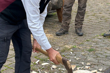 Hartmut Brückner, Vorstand der Schiltacher Flößer, zeigt - mit drei Axthieben - das Anlegen einer Dreieckskerbe als Bohransatz 