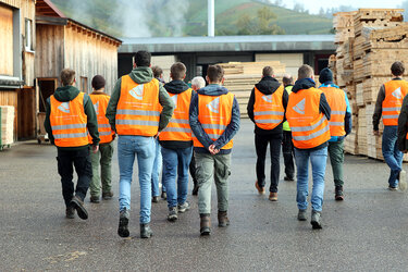 Studierende laufen über das Sägewerksgelände